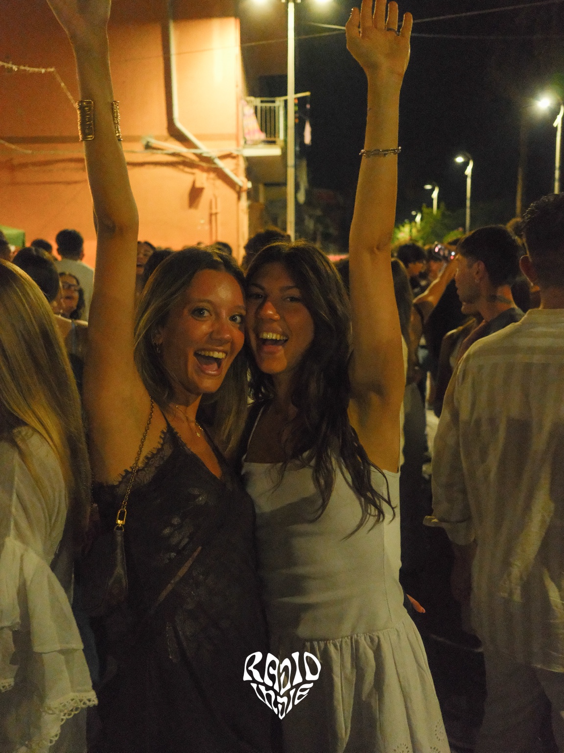 Due ragazze sorridono con le mani in alto